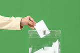 Voting woman near ballot box on green background