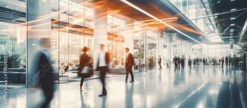  Bright business workplace with people in walking in blurred motion