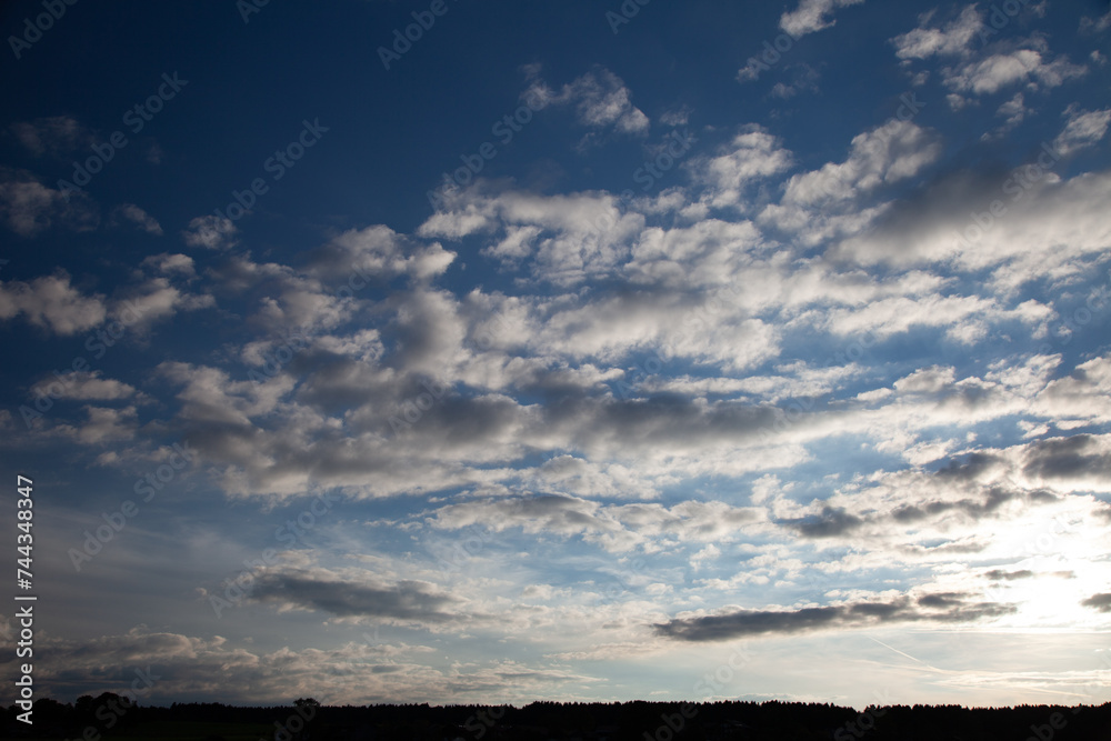 The sun radiates through the cloudy sky, casting a warm glow and adding beauty to the scene. The sun radiates through the cloudy sky, casting a warm glow and adding beauty to the scene.