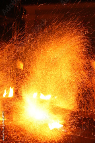Sparks of fire shot on long exposure creating a halo of fire. Fire show in the night