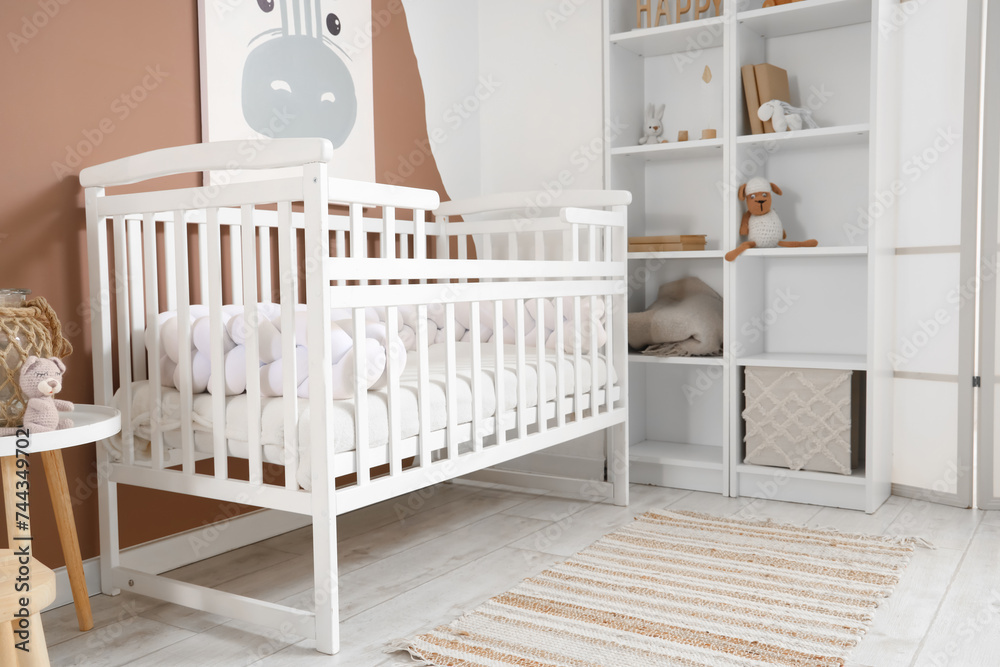 Interior of children's bedroom with baby crib and shelf unit Interior of children's bedroom with baby crib and shelf unit