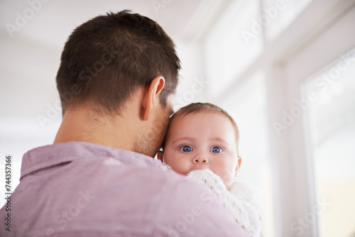 Father, baby and home with portrait, support and bonding together with newborn and love. Happy, family and dad with young child in a living room with parent care in a house carrying a calm infant