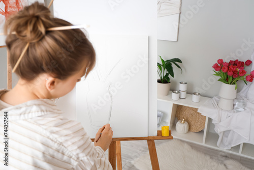Female artist painting on c...