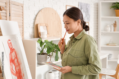 Female Asian artist paintin...