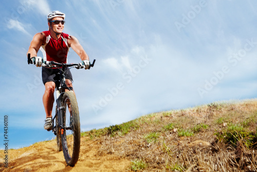 Nature, cyclist and man athlete with bicycle in park for marathon, race or competition training. Fitness, sports and male person cycling on bike for cardio workout or exercise in outdoor forest.