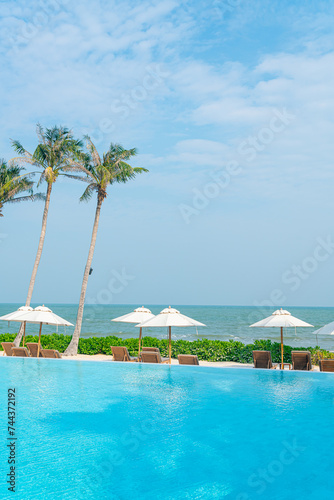 umbrella with bed pool around swimming pool with ocean sea background