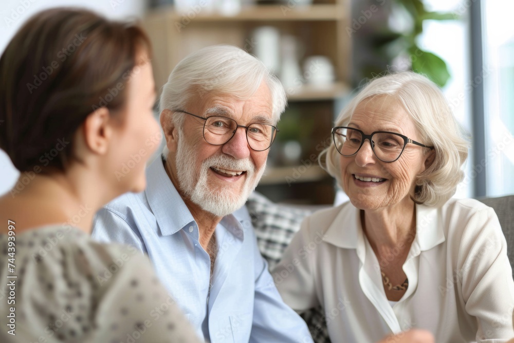 Senior couple discussing insurance plans with advisor joyfully Senior couple discussing insurance plans with advisor joyfully