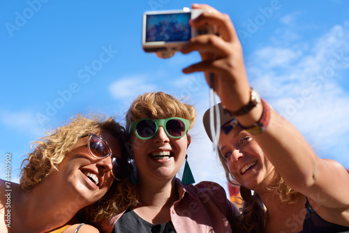 Friends, group and selfie outdoor for festival, photography and digital camera for portrait. Music, people and blue sky in summer, together and happy with culture of music in carnival and smile