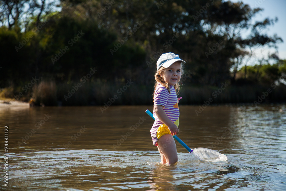 Little girl playing in the water where the river meets the sea Stock ...