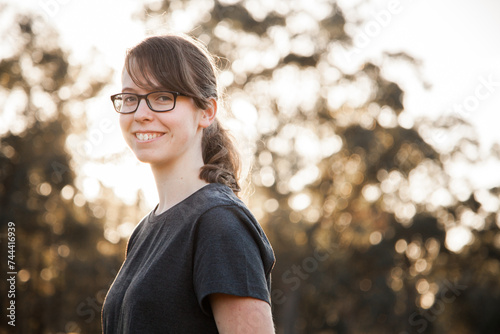 Portrait of a happy teenage girl with glasses smiling at the camera photo