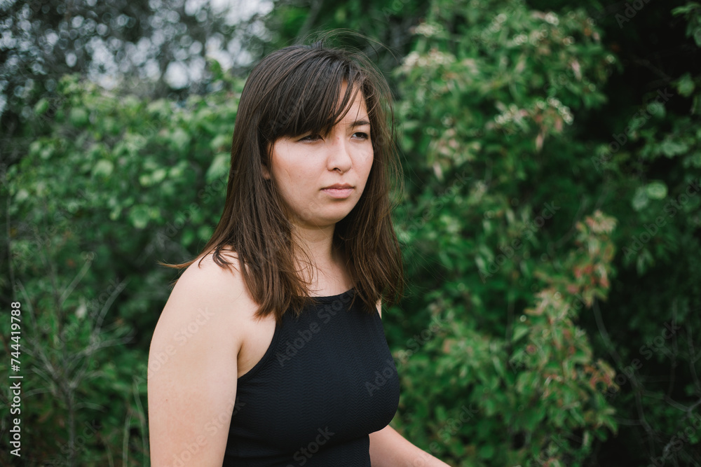 Young woman looks off into distance while outdoors with copy space Young woman looks off into distance while outdoors with copy space