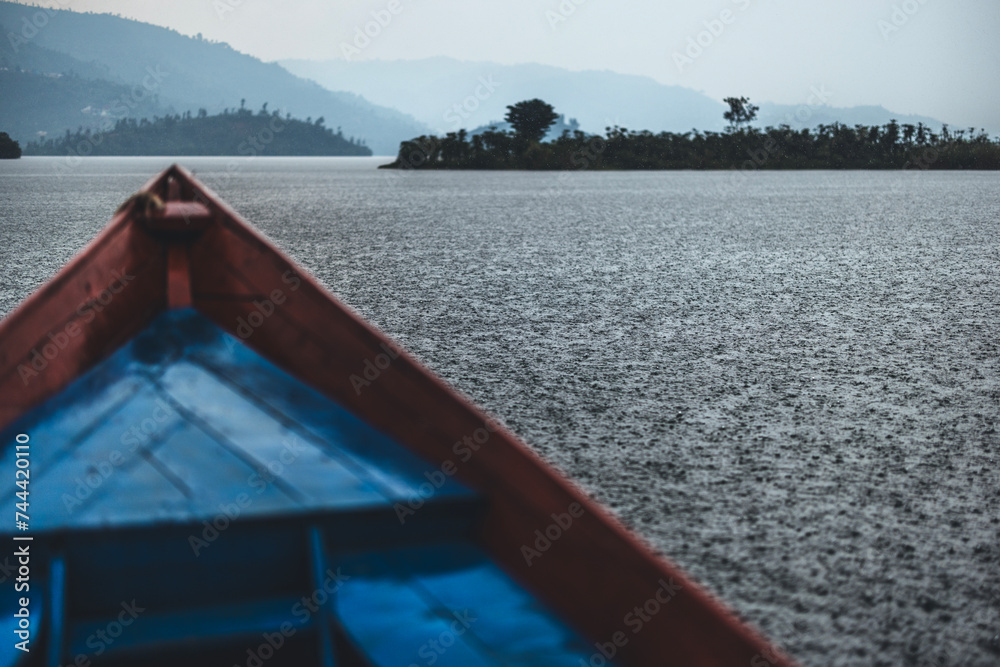 A boat navigates Lake Kivu, Rwanda in a heavy rain downpour
