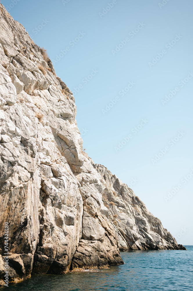 Rugged cliffs in blue seawater along Santorini coastline