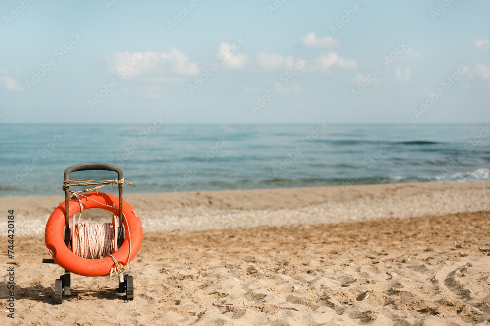 Life buoy ring in a cart on a sandy beach shore on a summer day