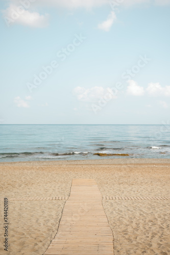 Wooden walkway on the beach leading towards the seashore
