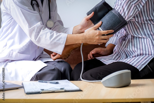 The doctor evaluates the patient with a stethoscope, blood pressure monitor and records the results, health medical checkup concept.
