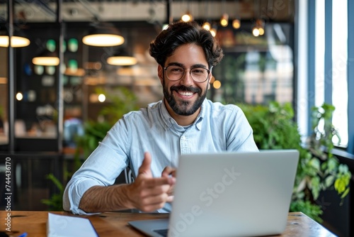 Happy young Latin business man hr manager team leader professional executive working in office looking at laptop computer talking having video conference call virtual online hybrid work, Generative AI