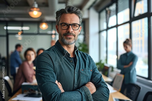 Smiling confident businessman leader looking at camera standing in office at team meeting. Male corporate leader ceo executive manager wearing glasses posing for business portrait arms  Generative AI