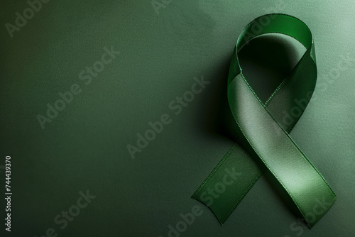 Green Awareness Ribbon on Dark Green Background, Copy Space