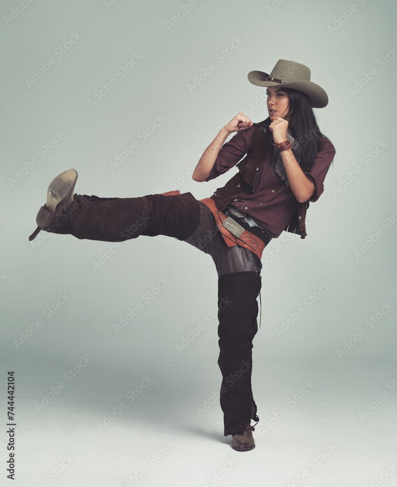 Φωτογραφία Cowgirl, kick and fight with fists in studio for western character, wild west outfit and hat for sheriff