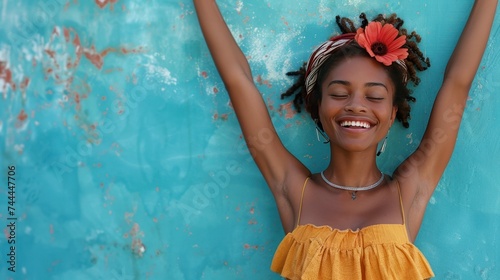 A joyful young woman enjoys dancing in front of a blue wall