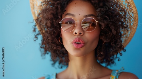 A portrait showcasing a lovely young woman wearing sunglasses and a summer straw hat