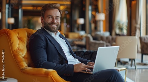 A young, smiling and successful male entrepreneur, dressed in a formal busine...