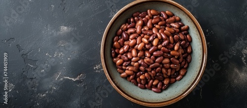 Aesthetic bowl filled with assorted beans on a dramatic black background setting