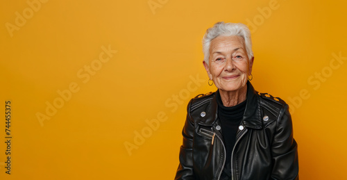 Top view of a smiling grandma in a leather jacket, symbolizing timeless rock and roll. Celebrating elderly strength and character, promoting inclusivity and empowerment. Copy space banner