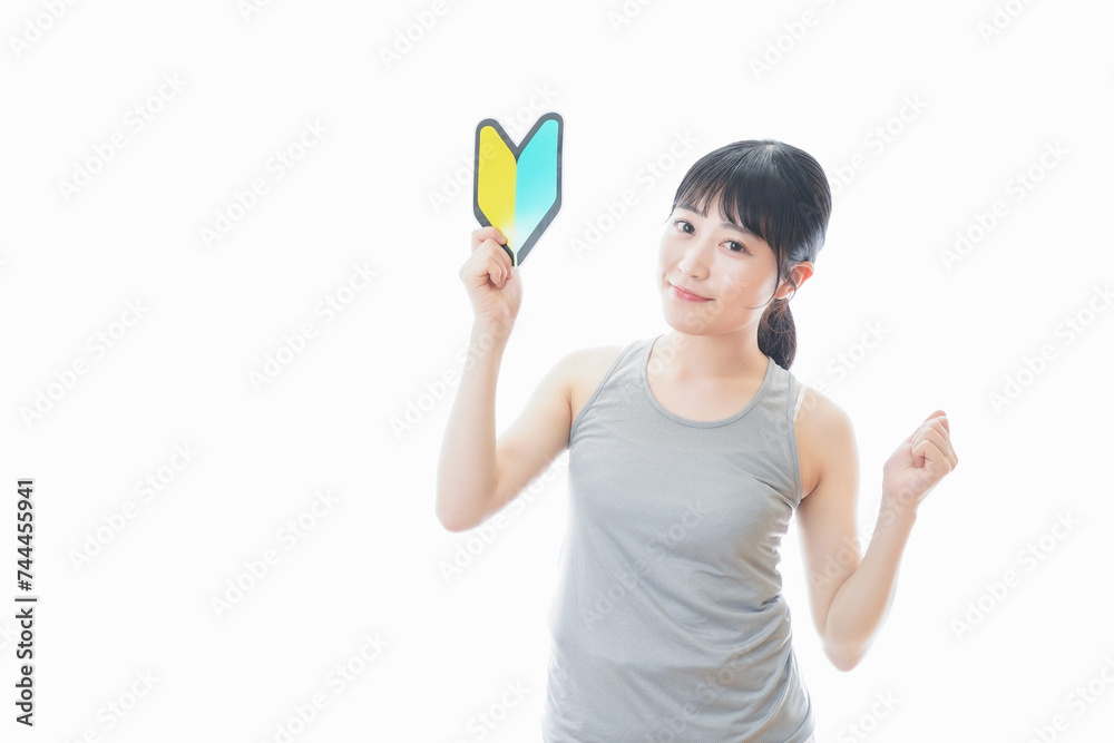 初心者マークを持つスポーツウェアを着た女性 初心者マークを持つスポーツウェアを着た女性