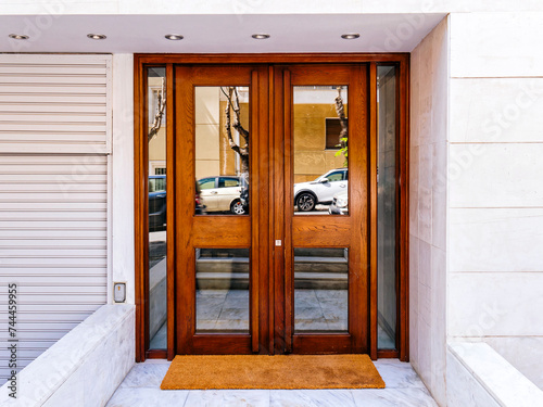 A wood and glass entrance door of a contemporary luxury apartment building. Visit Athens posh downtown, Greece.