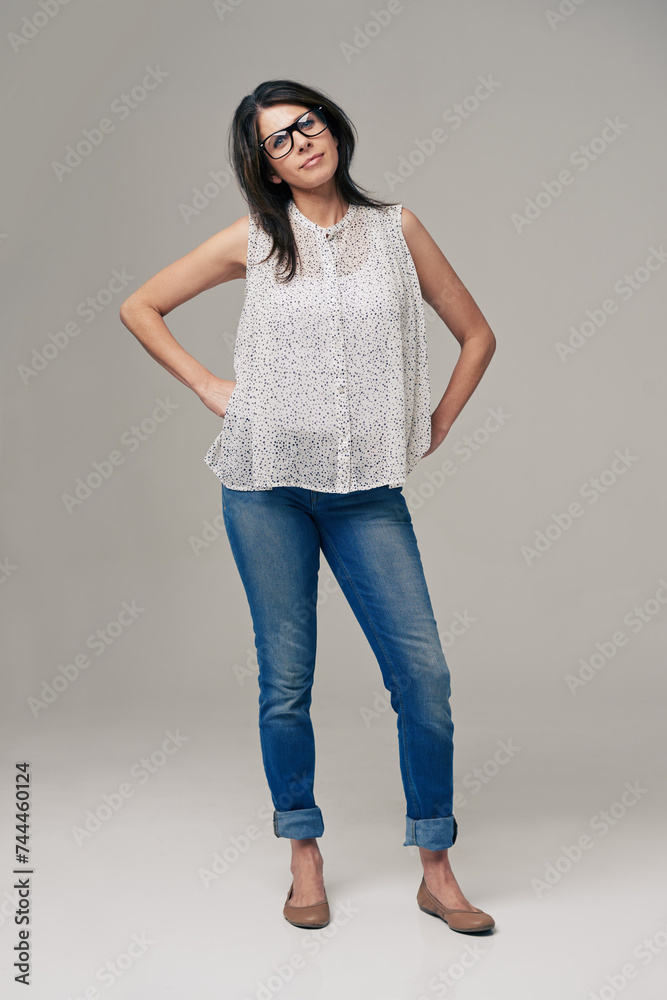 Happy, woman and portrait for fashion style in denim jeans on a gray studio background. Female person, brunette or adult with casual clothing, glasses or stylish outfit in confidence on mockup space Happy, woman and portrait for fashion style in denim jeans on a gray studio background. Female person, brunette or adult with casual clothing, glasses or stylish outfit in confidence on mockup space