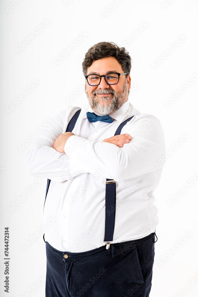 Confident plus size man in smart attire with bow tie and suspenders in studio portrait Confident plus size man in smart attire with bow tie and suspenders in studio portrait