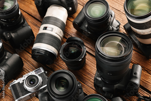 Modern cameras on wooden table, closeup. Professional photography equipment