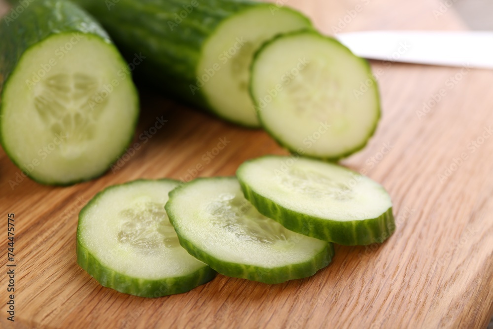 Fresh cucumbers on wooden cutting board, closeup Fresh cucumbers on wooden cutting board, closeup