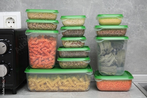 Plastic containers filled with food products on grey table in kitchen