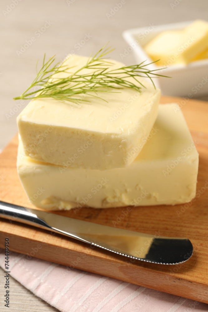 Tasty butter with dill and knife on wooden table, closeup