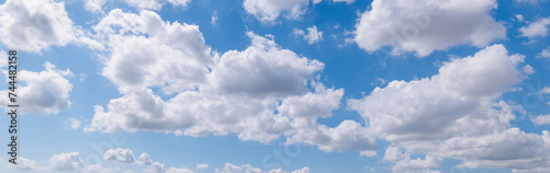 Panoramic view of clear blue sky and clouds, Blue sky background with tiny clouds. White fluffy clouds in the blue sky. Captivating stock photo featuring the mesmerizing beauty of the sky and clouds.