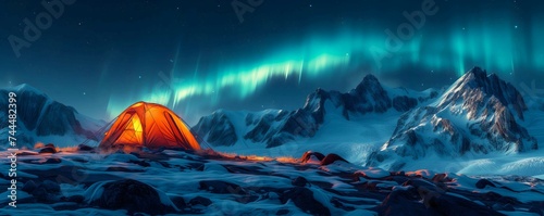 camping at night on mountain peak with green hues of the northern lights sky