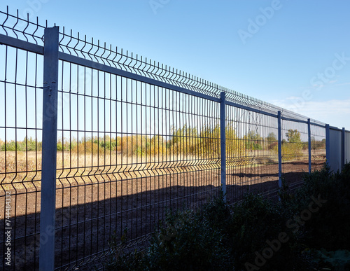 Metal wire fence to protect the territory. Painted wire mesh grille fence panels © supersomik