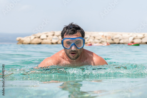 Man with diving mask in the sea  about to dive