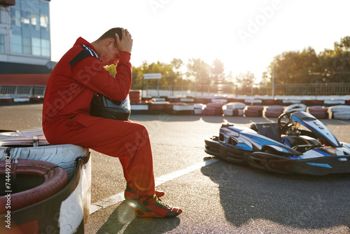 Frustrated go-cart racer in sportswear feeling sad and despair