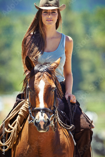 Woman, portrait and cowgirl with horse in countryside for ride, journey or outdoor adventure in nature. Female person or western rider with hat, saddle and animal stallion at ranch, farm or stable