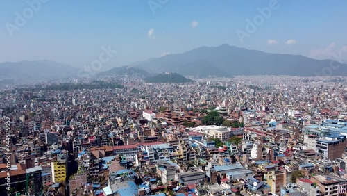 Aerial view of Kathmandu city, Nepal, showcasing the densely packed buildings and the majestic Himalayan mountains in the background.