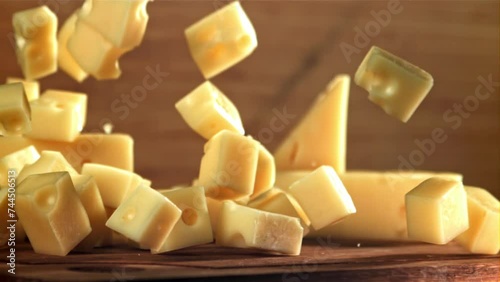 Super slow motion pieces of cheese fall onto a cutting board. Filmed on a high-speed camera at 1000 fps. High quality FullHD footage