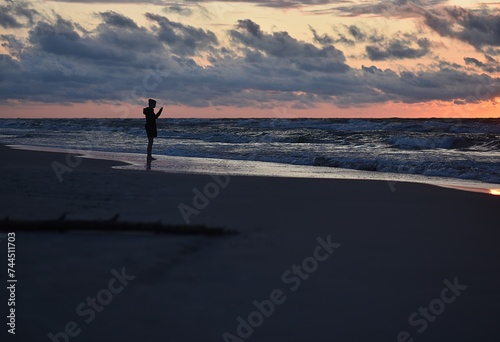 Fototapeta Naklejka Na Ścianę i Meble -  Walking on the beach by the Baltic Sea. Silhouette of a person