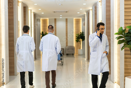 Doctors team in white lab coats of healthcare professional medical at modern hospital corridor, discussing patient care, healthcare, medical consultation, teamwork and collaboration, medical education