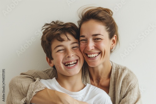 A woman and a boy smile and hug, sharing a happy gesture for the camera