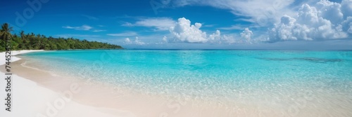 Tropical beach with white sand and crystal clear turquoise water in sea. Vibrant blue sky with small clouds