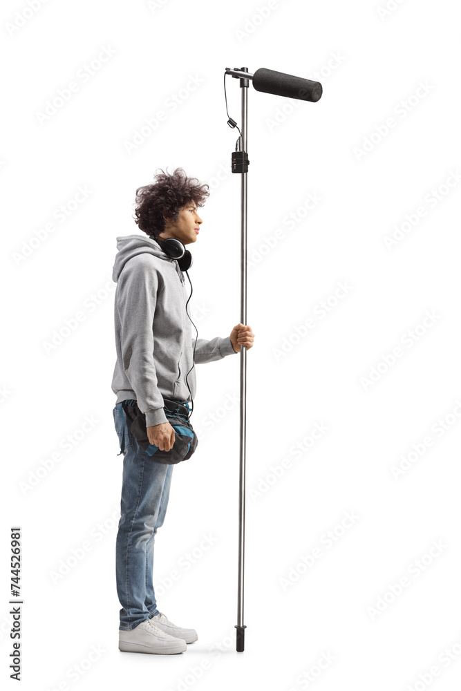 Full length profile shot of a boom operator holding a microphone Full length profile shot of a boom operator holding a microphone